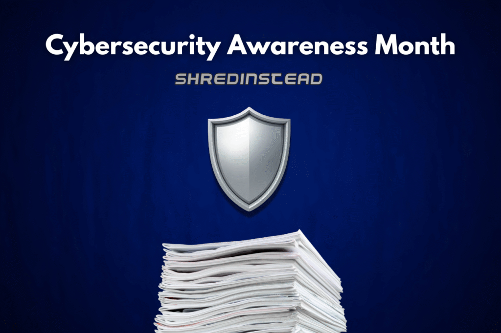 Photograph on a dark blue background with white text at the top reading, "Cybersecurity Awareness Month". Below that, silver text reads, "SHREDINSTEAD". In the center is a silver shield icon, and at the bottom is a large stack of white papers.